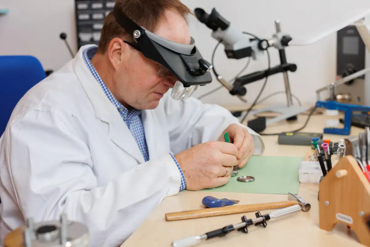 Uhrmacher wechselt Batterie einer Armbanduhr